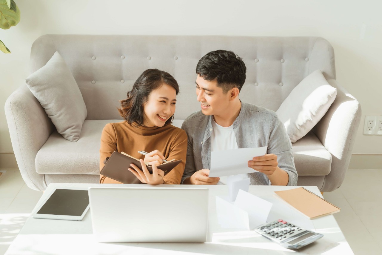 Young couple happily planning finances together