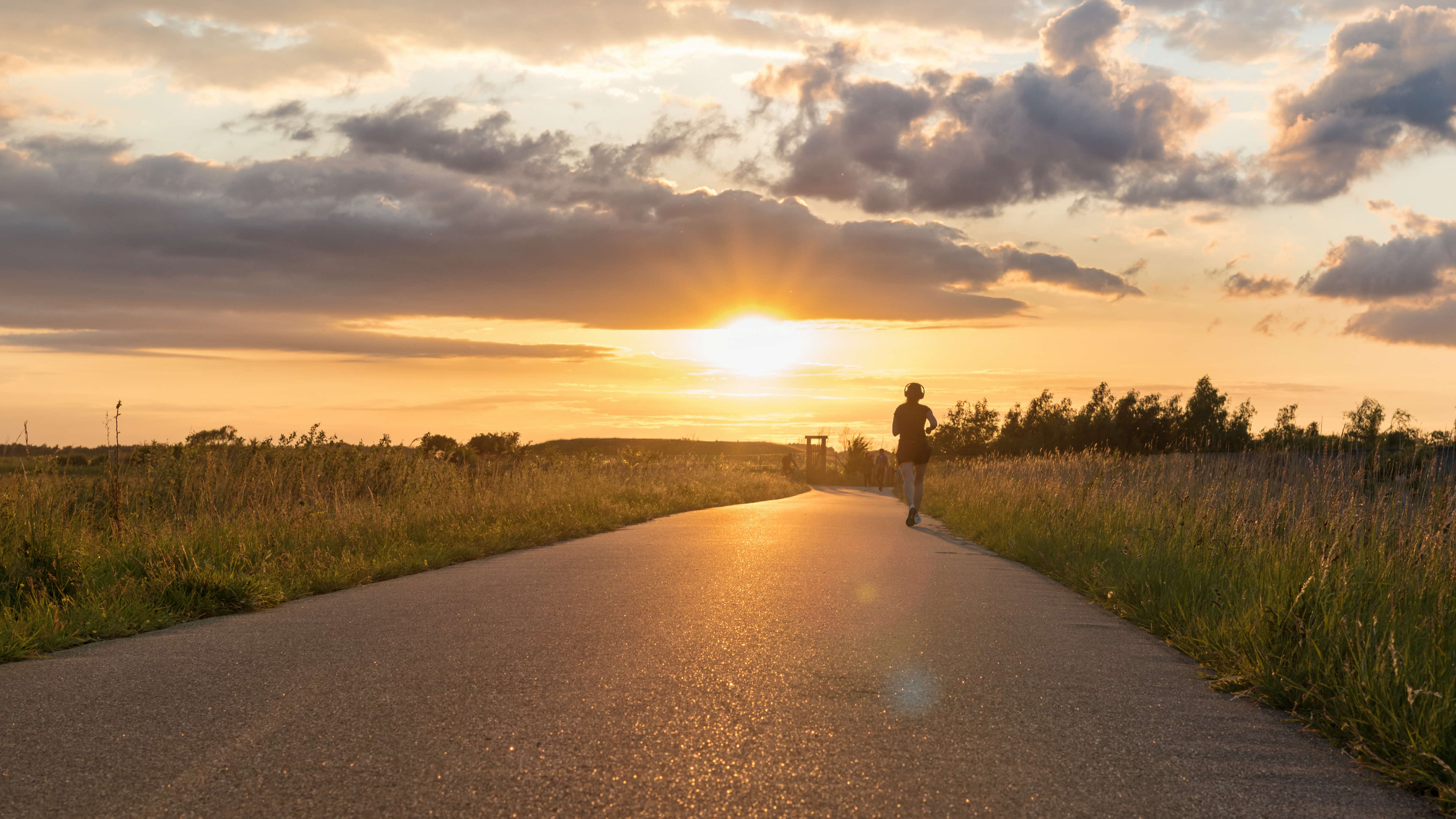 Lady running on a path into the sunset