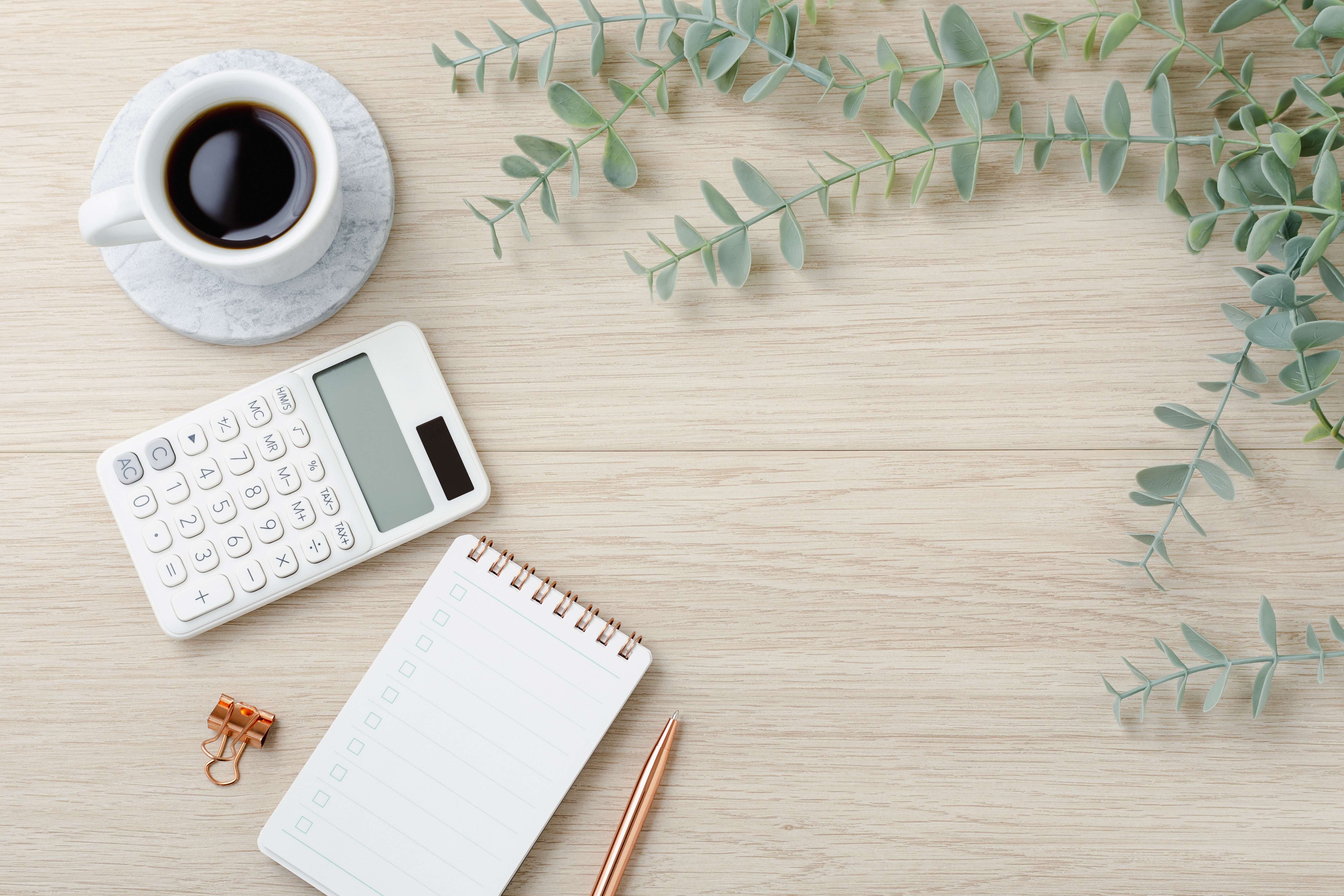 Aesthetic coffee, calculator, notebook and stationery on a table