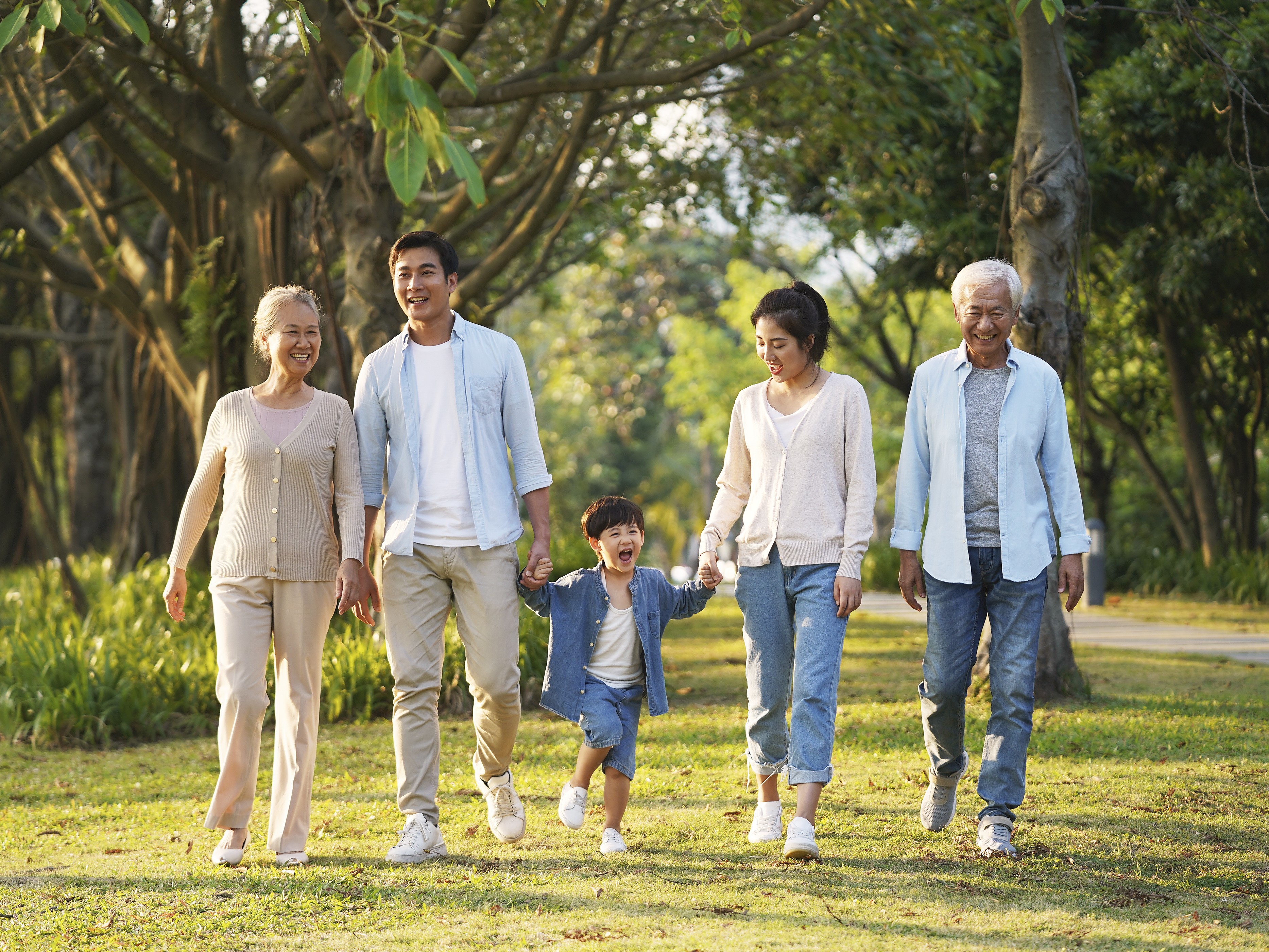 3 generation Asian family walking in a park