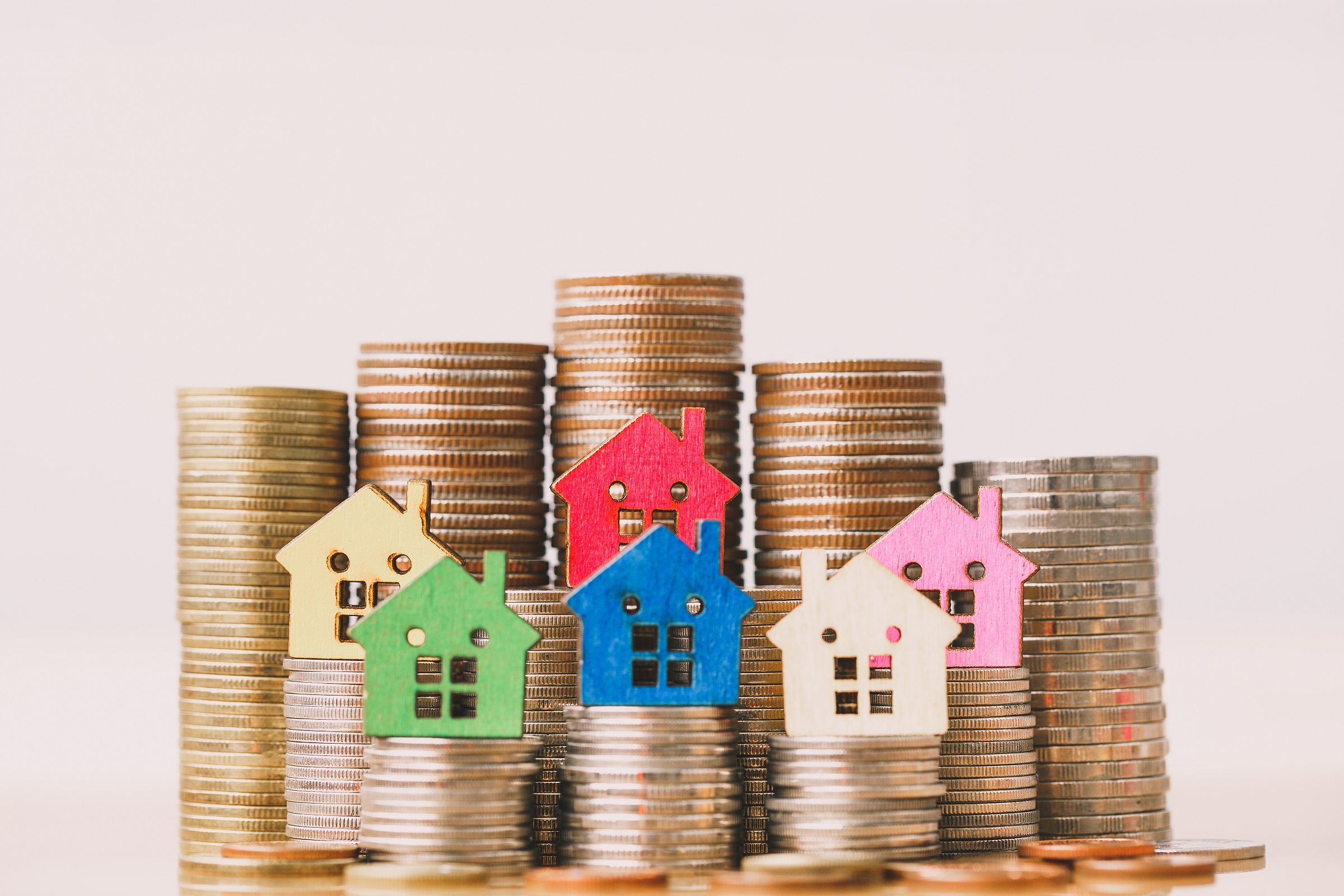 colourful houses on a stack of coins