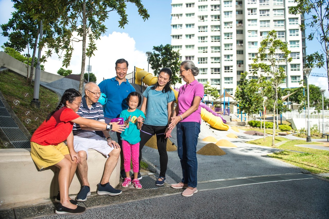 asian family in front of a block of flats enjoying the company of one another